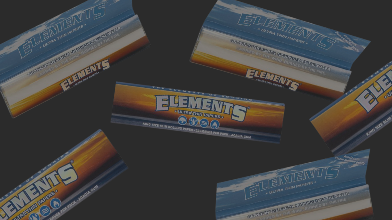 Elements Slim King Size Longpapes Banner: mehrere „Elements Ultra Thin Papers“-Packungen in Blau-Orange auf dunkelgrauem Hintergrund, mittig eine horizontale King-Size-Packung, weitere Packungen schräg rundherum verteilt.